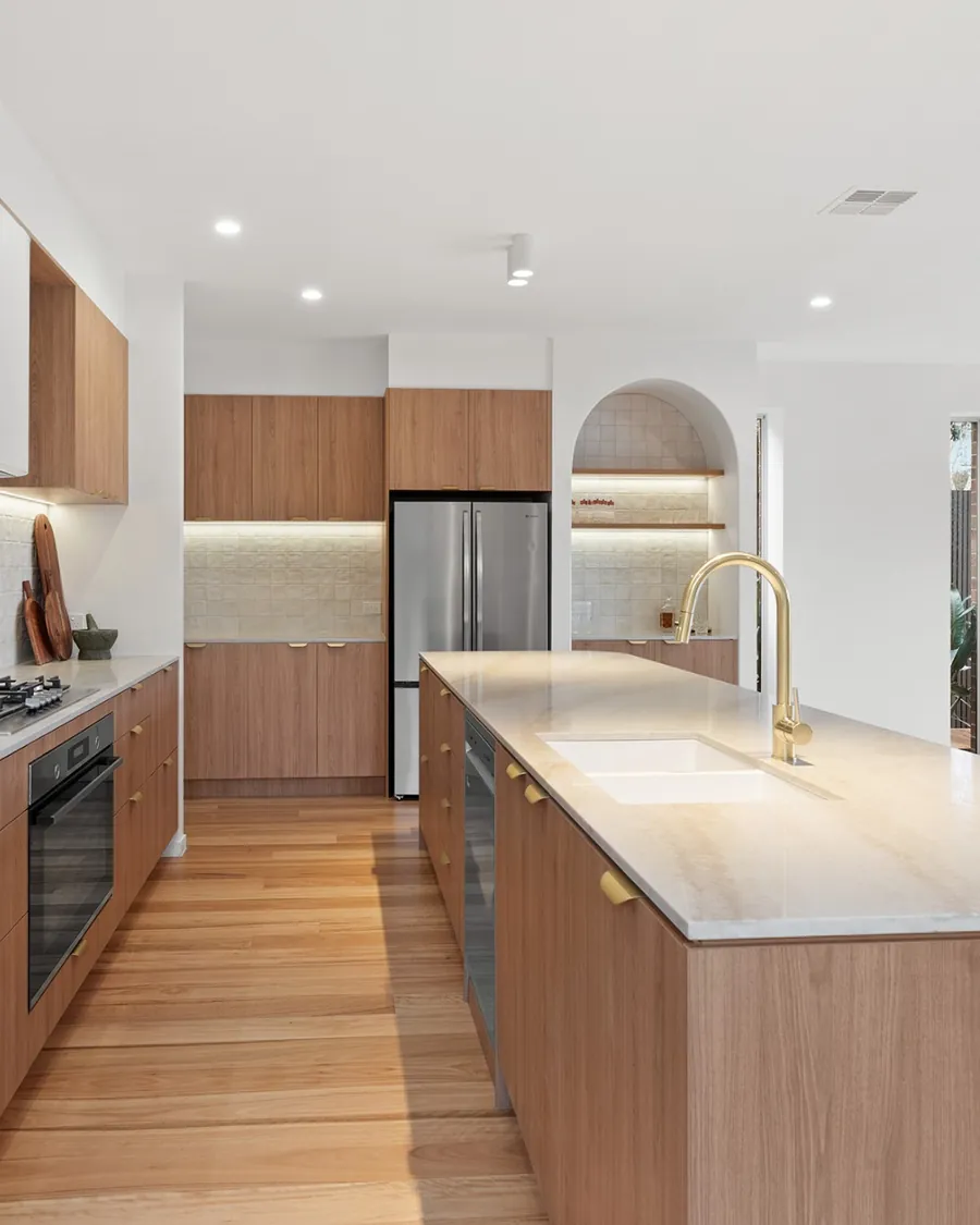 Organic Curves kitchen with a curved stone-topped island, an arched display niche and timber cabinetry
