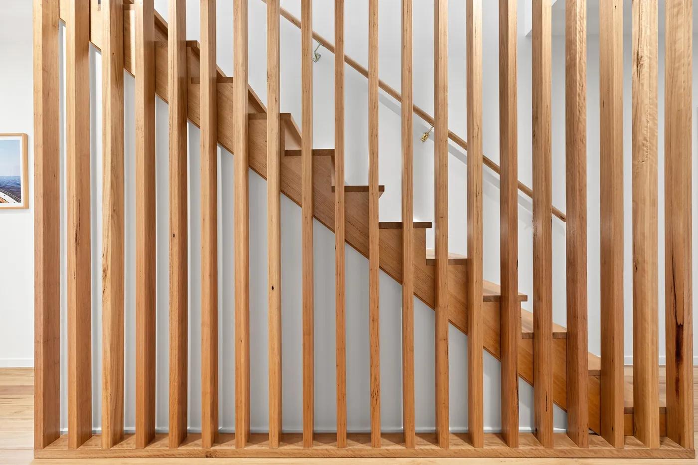 Timber staircase behind a screen of vertical timber battens
