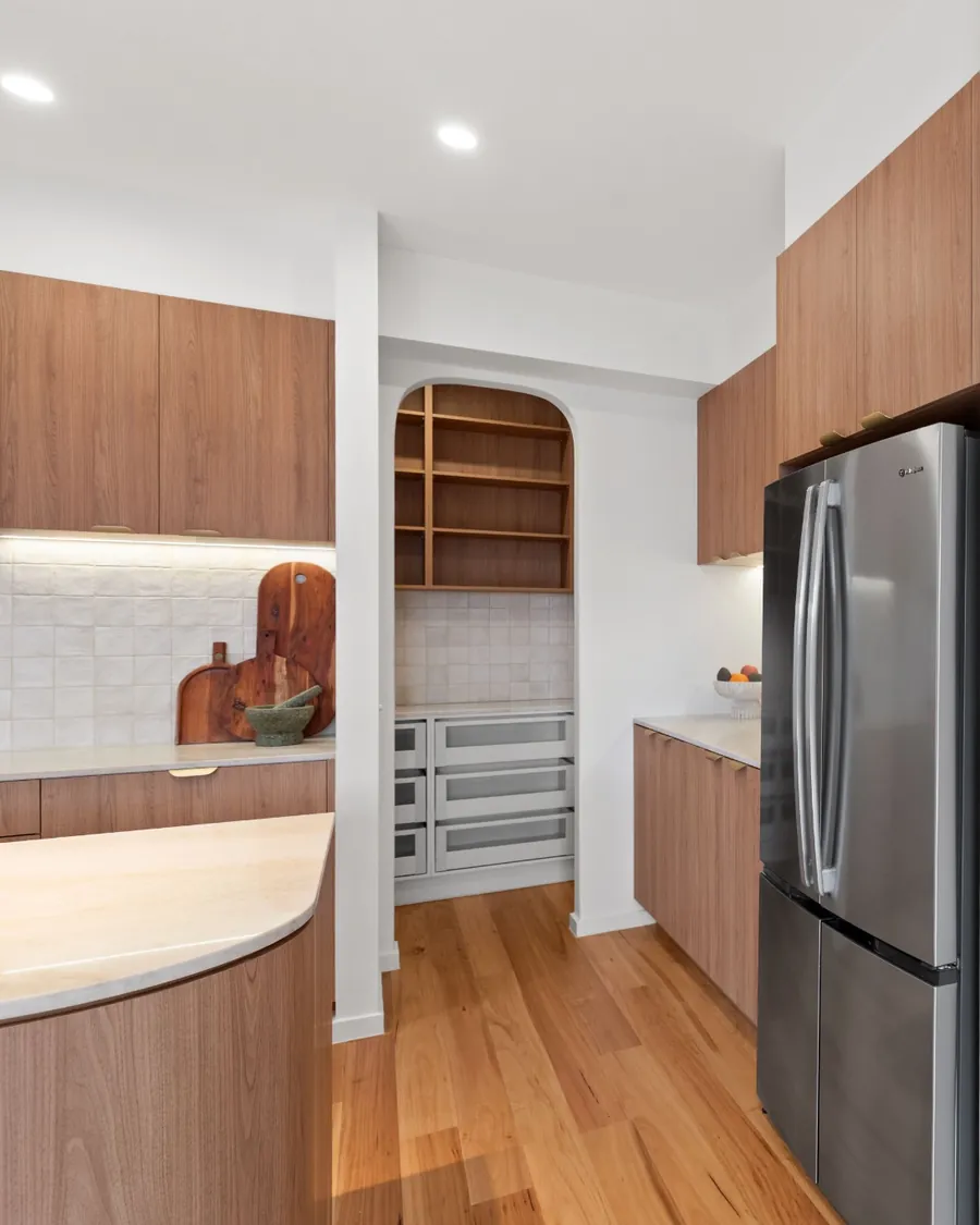 Organic Curves kitchen opening through an arched doorway to the butler’s pantry