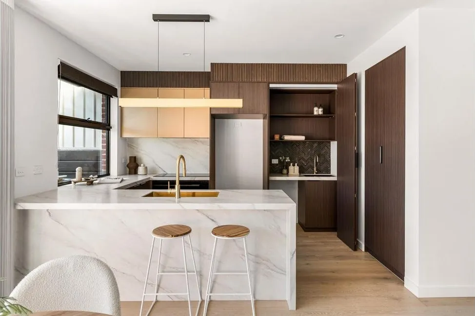 Tonal Depth kitchen with a veined porcelain island and dark timber cabinetry