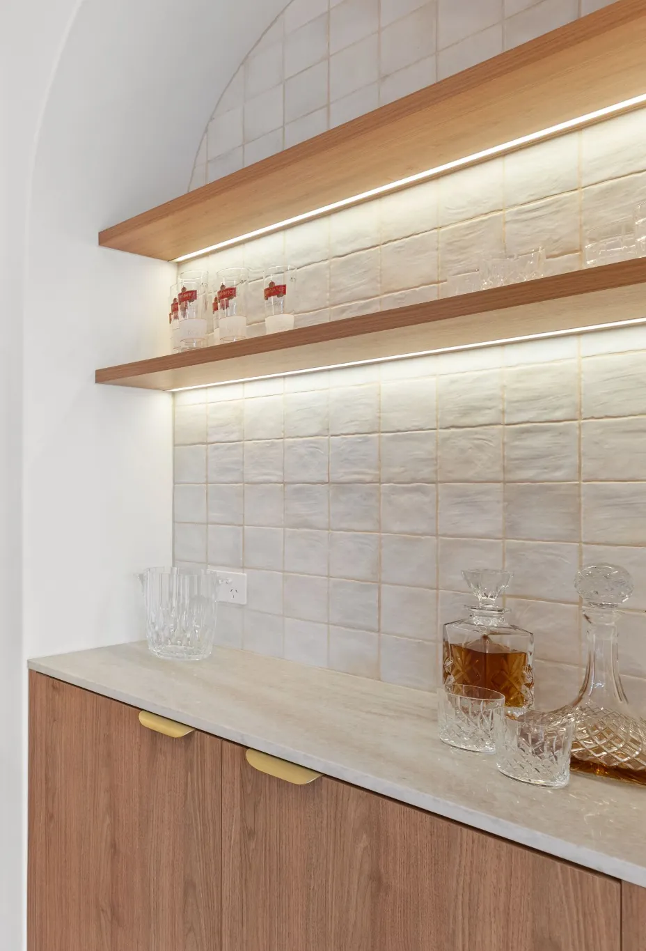 Organic Curves kitchen with an arched, lit dry bar and walnut cabinetry